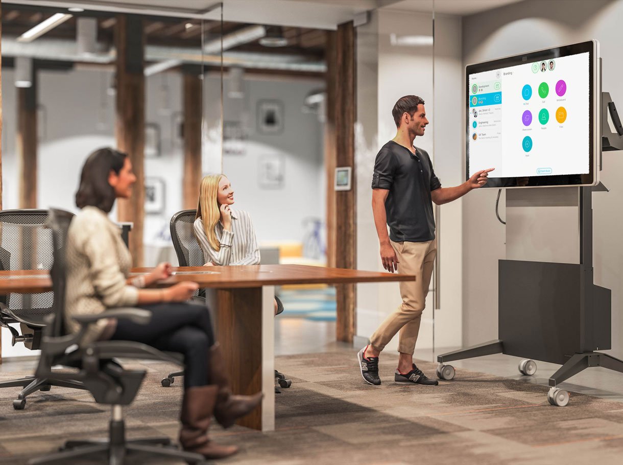 Un homme montre un tableau de collaboration dans une salle de réunion.